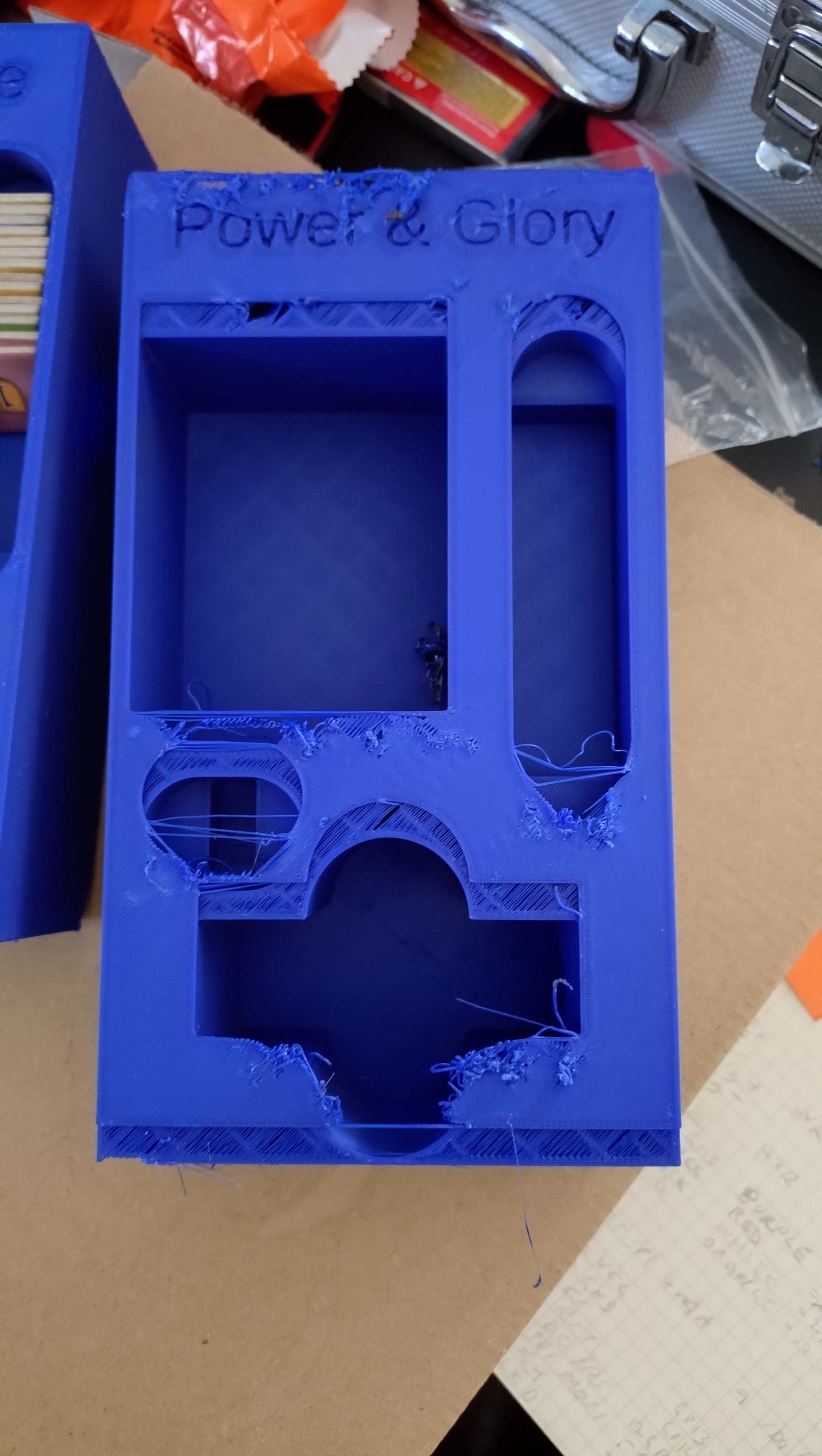 A royal blue print of a board game insert, the final 2 layers of the print are shifted up by approx 4mm and the top is somewhat scruffy&10;