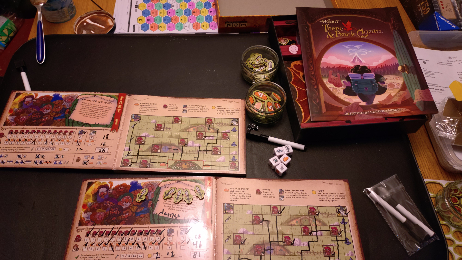 2 finished boards for the first chapter of the game, left on each is a score board counting points for dwarves arrived at Bag End, and whether they get bread, on the right is a map with lines connecting the dwarves. The dice show map squares that can be used on the map.